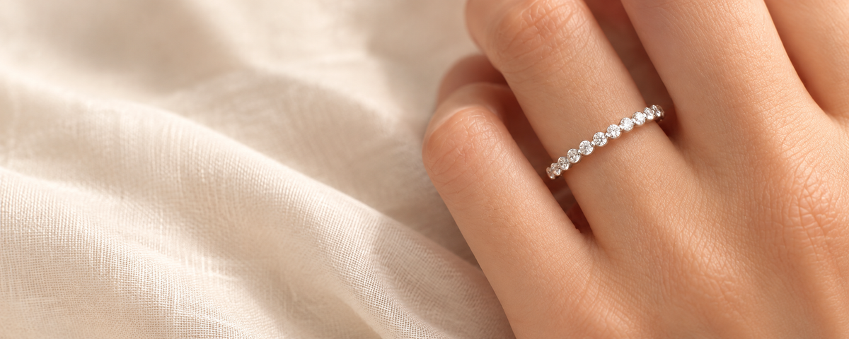 Delicate clear-stone wedding band on a hand